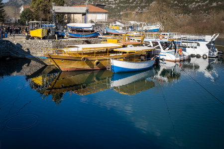 Boats on the calm water of the lake - about February 2023, Virpazar, Montenegroのeditorial素材