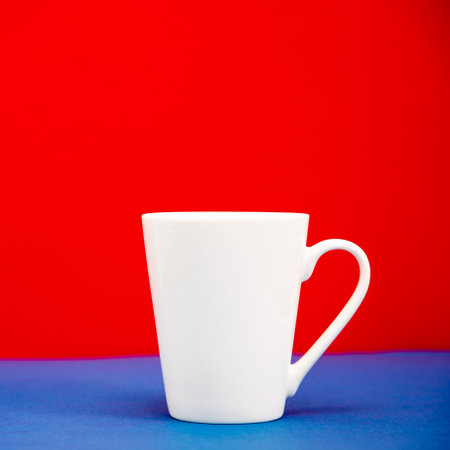 Mockup in the form of a white mug on a red-blue backgroundの写真素材