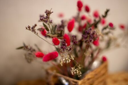 Branches bright pink dried flowers in a wicker basket.の写真素材