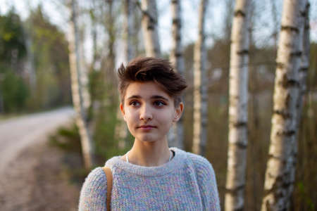 Portrait of a teenage girl with tanned skin lifestyle. Short dark hair. On the background of a sandy roadの写真素材