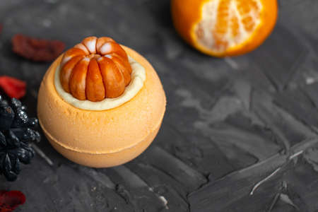 Orange bright handmade bath bomb in the shape of a ripe juicy tangerine. Zero waste. An...