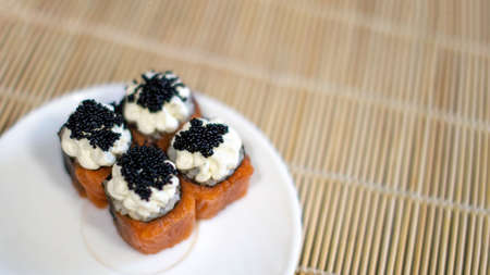 Four sushi in a plate. In a white plate of sushi with red fish, salmon, cottage cheese and caviar....