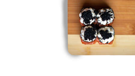 Banner with sushi, rolls on bamboo natural kitchen board. Isolated white background. Sushi with red fish, cottage cheese and caviar.の写真素材