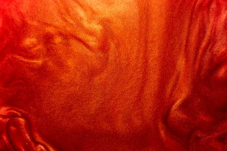 Defocus. Abstract particles of red, orange, glitter flow under water. Brilliant luxurious background. Movement of the shimmer in the water is red.の写真素材