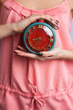 Beautiful sweet girl holding alarm clockの写真素材