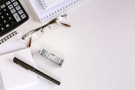 Office workplace, money, calculator and stationery on the table top view. Dollars