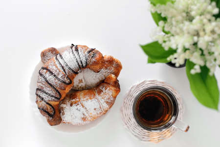 a healthy breakfast of tea and croissants on the dining tableの写真素材