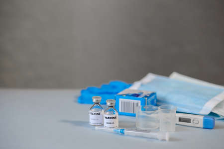 vials of coronavirus vaccine, medical supplies on a blue surface, covid-19 vaccination, medical...