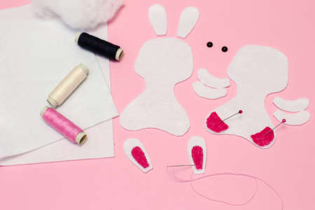 Step-by-step instructions for DIY Easter Bunny made of felt. Step 2: Sew the bright pink details on the rabbit earsの写真素材