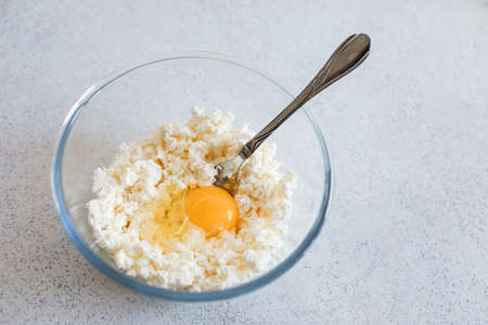 a bowl of cottage cheese and a chicken egg on the table, cooking