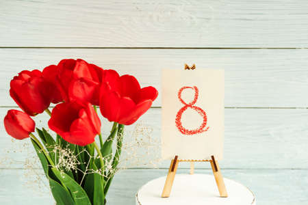 Card with the number 8 with red tulips on a white background for March 8. greeting cardの写真素材