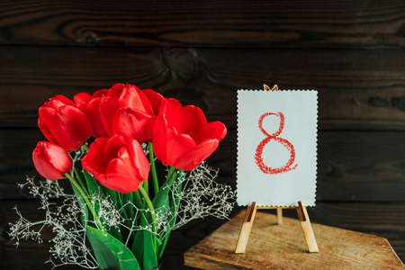 Card with the number 8 with red tulips on a dark background for March 8. greeting cardの写真素材