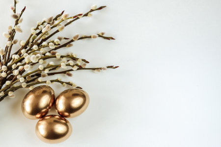 painted golden eggs and willow twigs. Easter composition with a copy of the space