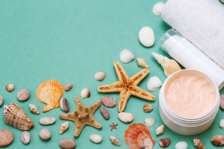 flat lay spa concept, beautiful background with care products, towel, shells and starfish on a...