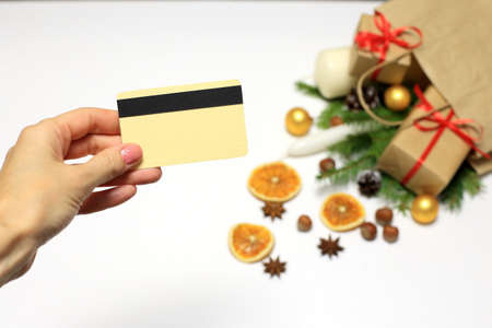 Christmas shopping concept. Hand with a credit card, a bag of groceries, champagne and gifts on a white background. Online shopping, credit card paymenの写真素材