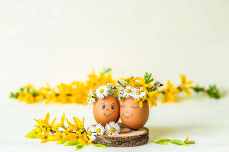 Easter composition with eggs, yellow flowering branches on a light paper background.の写真素材