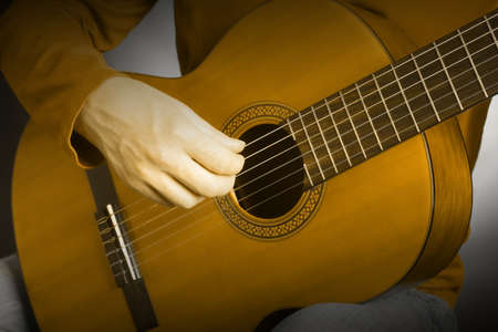 Acoustic guitar playing details with classical guitarist hands close up