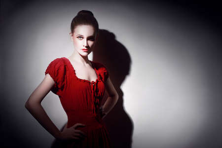Young woman in red portrait  Sexy model in red dress in darkness の写真素材