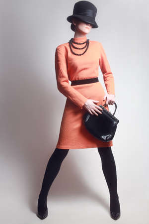 Stylish woman Elegant Fashion model in orange dress and hatの写真素材