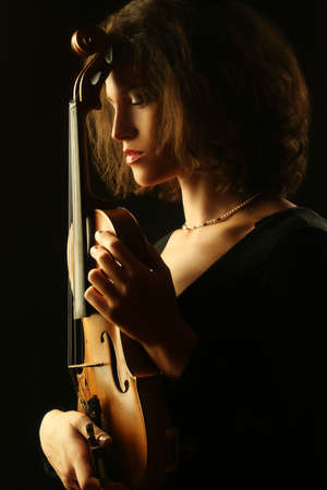 Woman with violin dark portrait of violinist musicianの写真素材
