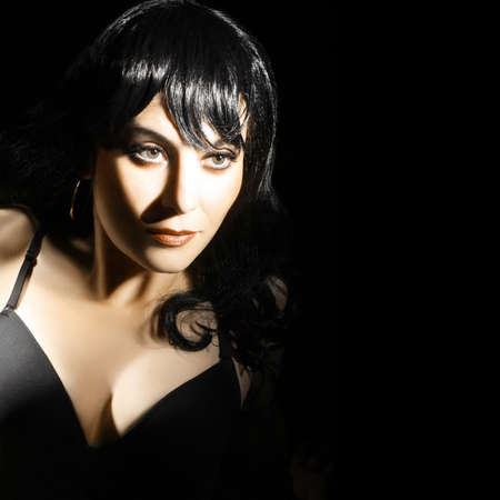 Brunette woman portrait. Fashion model face isolated on blackの写真素材