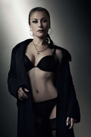 Sexy woman in black lingerie and coat sensual woman fashion model portraitの写真素材