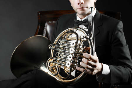 French horn player. Music instrument horn in the hands of hornist