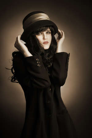 Brunette woman in black hat and dress Portrait of young romantic womanの写真素材