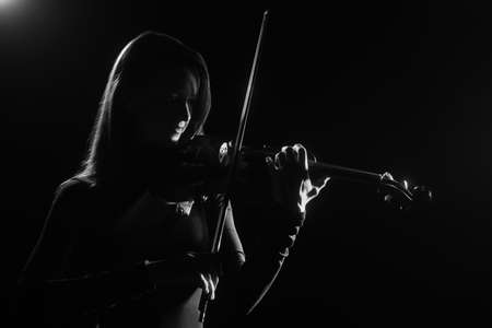 Violin player Violinist playing violin classical music concert in darknessの写真素材