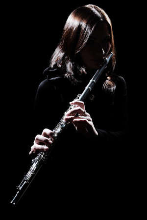 Flute player Flutist playing flute instrument. Classical musician isolated on blackの写真素材