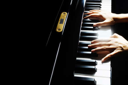 Piano player. Pianist hands piano grand music instrument close up keyboardの写真素材