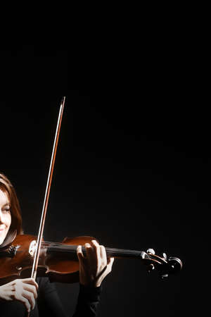 Violin player. Violinist playing violin hands closeup music instrument isolated on black backgroundの写真素材