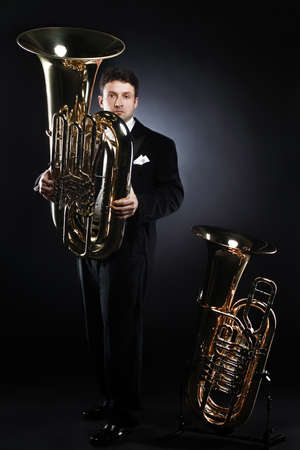 Tuba player brass instrument. Classical musician portrait. man horn player.の写真素材