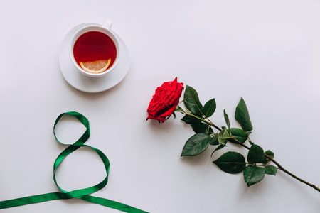 Woman day 8 march with ribbon, red Rose and lemon tea on a white backgroundの写真素材