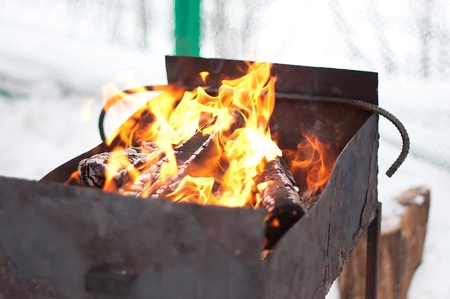 Fire in a brazier. Fire wood, fire, snow, an old iron brazier for a shish kebab.
の写真素材