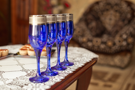 Dark blue glasses on a table stand in a row.の写真素材