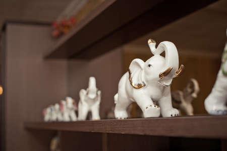 The shelf with figures of elephants of white color from a bone.の写真素材