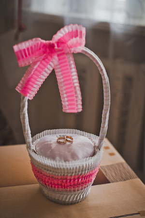 Beautiful basket for wedding gold rings with pink bows.の写真素材
