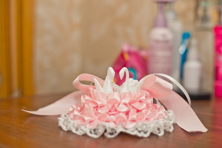 Openwork ornament on a foot of the bride from a pink and white fabric.の写真素材