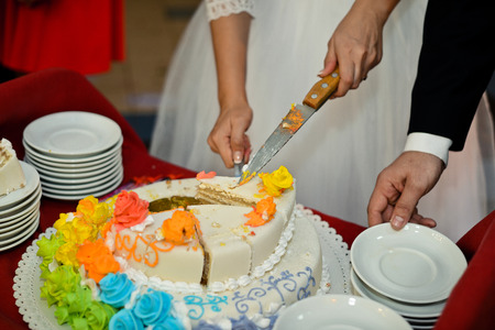 Process of cutting of a pie by the bride and the groom on pieces.