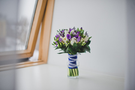 Bouquet lying in curtains on a window sill.の写真素材