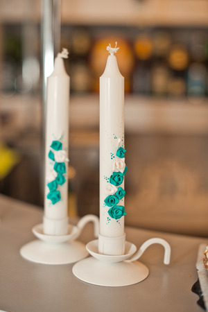The decorated candles with violet flowers on a table.の写真素材