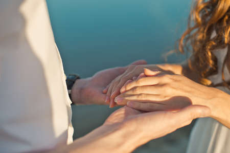 Man's hands embrace hands of the girl.の写真素材