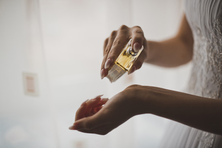 The young woman puts spirits on a hand wrist.