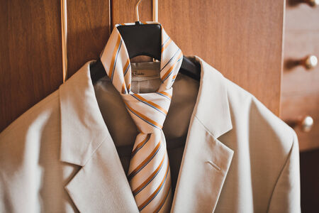 The man's suit and tie hangs on a hanger.の写真素材