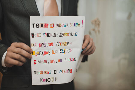 The letter from the cut-out letters in hands of the man.の写真素材