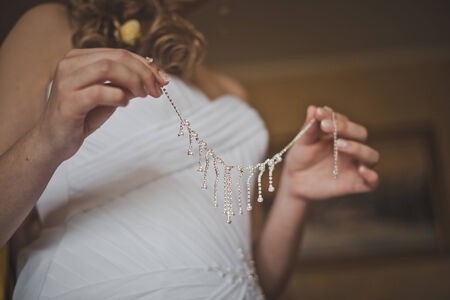 The bride dresses a necklace.の写真素材