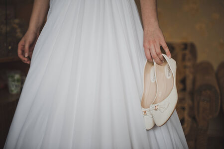 Close up of hands of the girl holding shoes.の写真素材