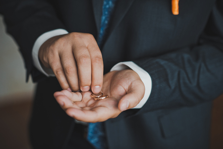 The young man holds gold ornaments which is going to present to the bride.の写真素材