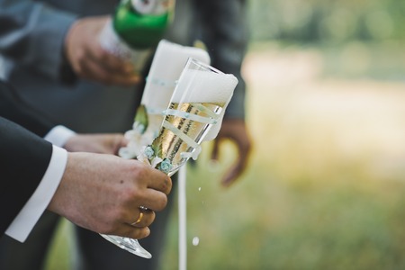 Process of filling by champagne of champagne in glasses outdoors.の写真素材